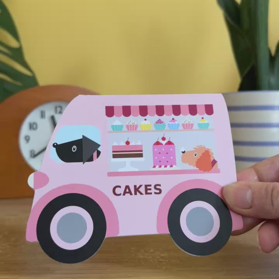 card cut into the shape of a vintage pink van selling cakes